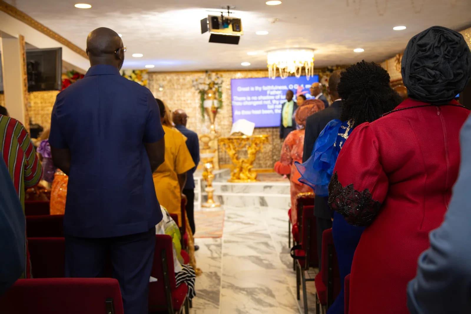 Full congregation on their feet singing in unison — wide room shot