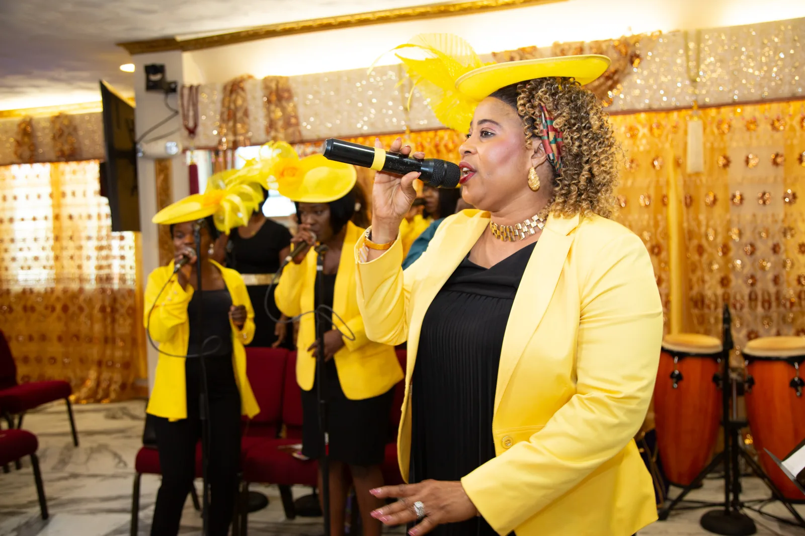 Lead choir singer belting powerfully into the mic